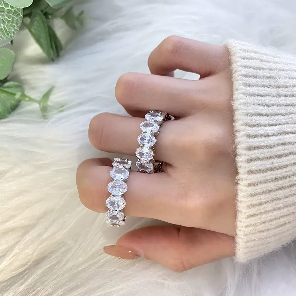 Bagues argentées serties de pierres zircon ovales portées à la main