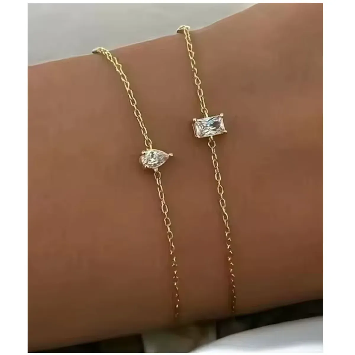 Bracelet doré fin avec deux pierres zircon en forme de poire et rectangle