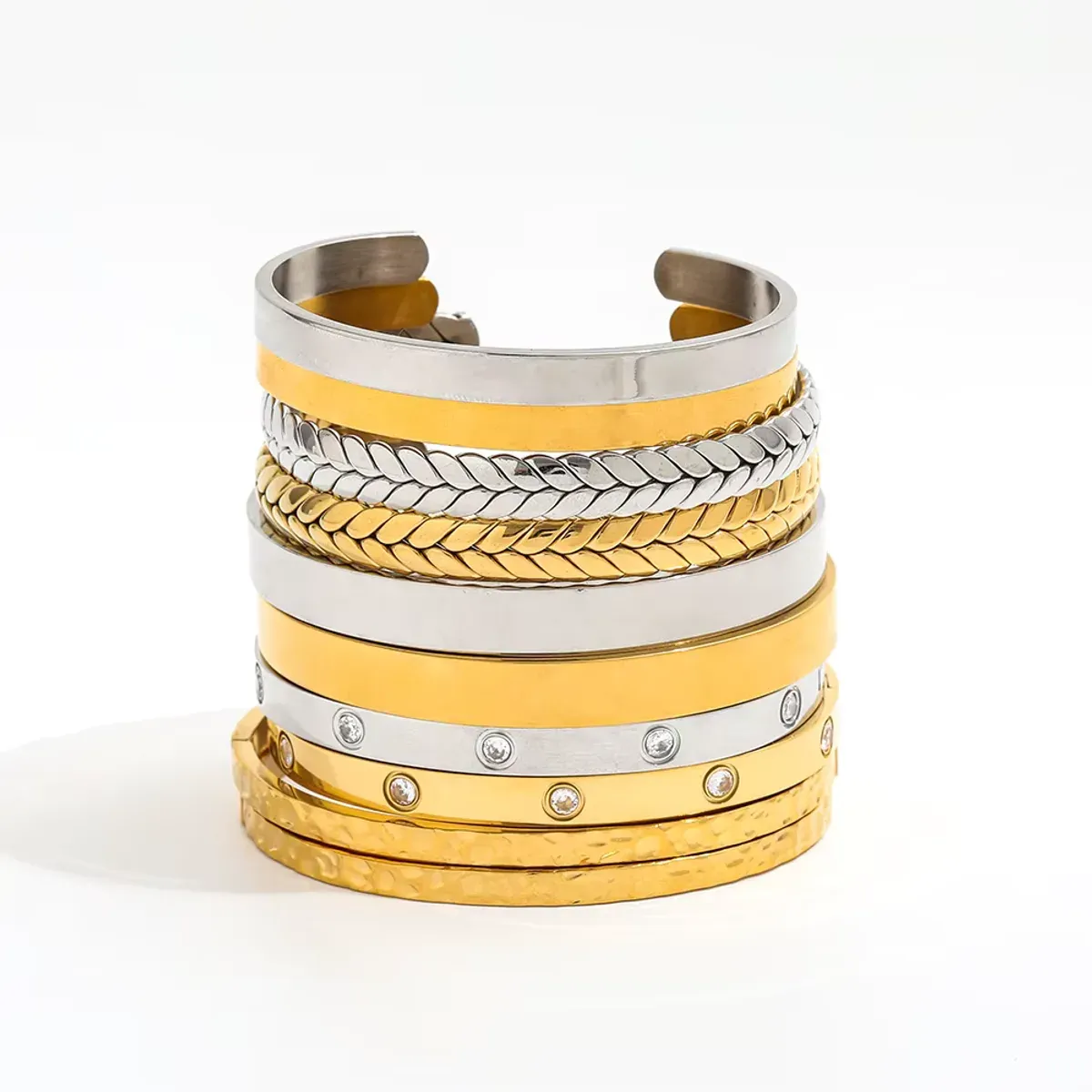 Pile de bracelets manchettes dorés et argentés avec textures variées